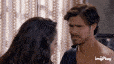 a man and a woman are looking at each other in front of a curtain with imgplay written on the bottom right