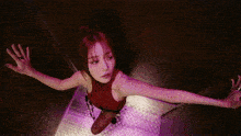 a woman in a red top is standing in an elevator