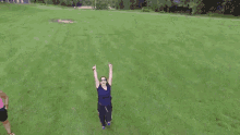 a woman is jumping in the air with her arms in the air
