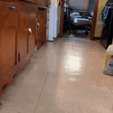 a kitchen floor with a bottle of clorox on it