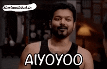 a man in a black tank top is smiling and says aiyoyoo