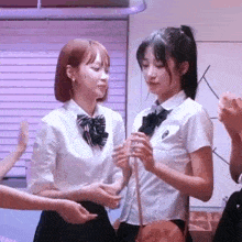 a group of young women in school uniforms are standing next to each other .