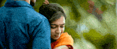 a man in a blue shirt is hugging a woman