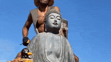 a man is working on a statue of buddha
