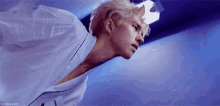 a man in a white shirt is floating in the air in a blue room .