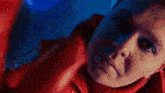 a close up of a woman 's face in a red jacket
