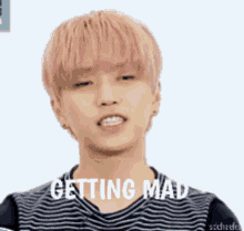 a young man with pink hair is wearing a striped shirt and is getting mad