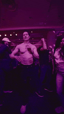 a man without a shirt is dancing in a crowd of people