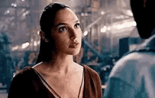 a woman is standing next to a man in a dark room looking at him .