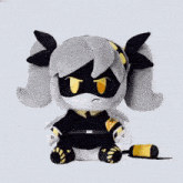 a black and white stuffed animal with a yellow triangle on the bottom