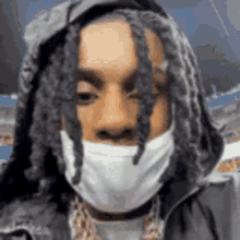a close up of a person wearing a mask and a hood .