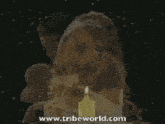 a woman is holding a lit candle and the website www.tribeworld.com is visible behind her
