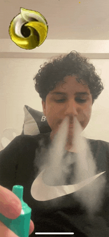 a man wearing a nike shirt is blowing smoke