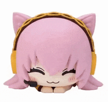 a figurine of a girl with pink hair and cat ears wearing headphones .