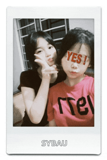 two girls posing for a picture with one wearing a pink shirt that says yes