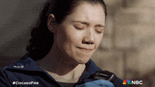 a woman is crying while holding a motorola device in her hand
