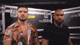 two men are standing in front of a case that says mtrd 9