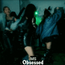 a group of women are dancing in a dark room with the words ms obsessed on the bottom