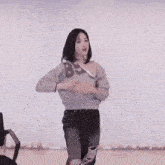 a woman is pointing at the camera with her finger .