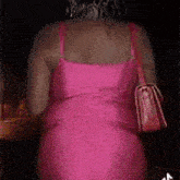 the back of a woman in a pink dress is shown .