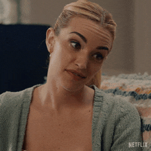 a woman is sitting on a couch with a netflix logo on the bottom right
