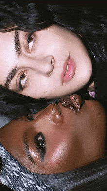 two women laying face to face with one wearing a headband that says gucci