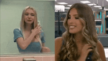 two women are standing next to each other in front of a mirror . one of the women is crying and the other is smiling .