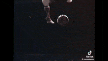a soccer player is kicking a soccer ball on the beach .