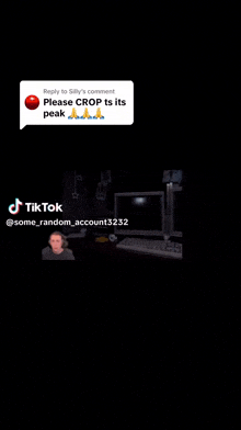a man is sitting at a desk with two computer monitors and a keyboard in a dark room .