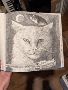 a black and white drawing of a cat with a fish and a moon on its head