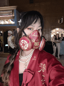 a woman wearing a red robe and a mask with chinese characters on it