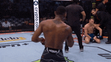 a man standing in a boxing ring with a crypto.com banner behind him
