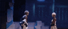 a man and a woman are dancing on a stage with a blue background