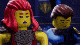 two lego figures are standing next to each other and one of them has a red hair