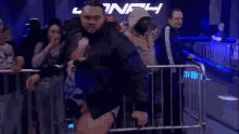 a man stands in front of a crowd in front of a sign that says onf4