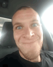 a man with a beard is making a funny face in the back seat of a car