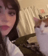a woman is taking a selfie with a cat in front of her .