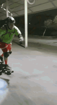 a person wearing a green shirt and red shorts rides a skateboard