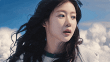 a close up of a woman 's face against a blue sky