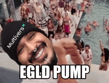 a man wearing a beanie with the word multiverse on it smiles in front of a crowd