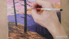a person is painting a landscape with the words made in animotica below it
