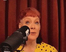 a woman stands in front of a shure microphone with the words absolut written around her