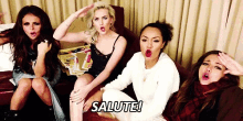 a group of girls are sitting on a couch with their mouths open and the words salute written above them .
