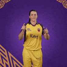 a man wearing a yellow shirt that says kay on the front