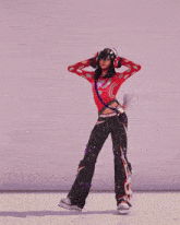 a girl in a red jacket and black pants is dancing