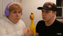 a boy wearing headphones shakes hands with another boy