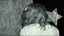 a woman 's head is shown in a black and white photo with a star in the corner