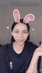 a woman wearing bunny ears on her head looks at the camera