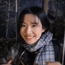 a close up of a woman wearing a scarf and smiling