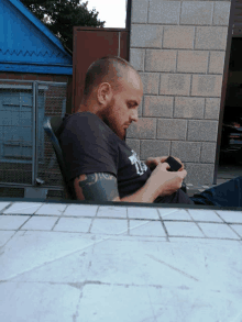 a man with a tattoo on his arm wearing a shirt that says ' t.j. ' on it